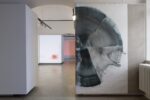 Foto eines Ausstellungsraumes mit abstrakter Malerei. Die Malereien zeigen Halbkreise. Im Hintergrund sind zwei weitere Ausstellungsräume mit abstrakter Malerei und Videoprojektion zu erkennen.