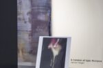 Foto eines Ausstellungsraumes mit abstrakter Malerei durch ein Schaufenster aufgenommen.