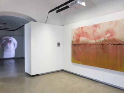 Foto eines Ausstellungsraumes mit einer abstrakten Malerei und einem Pigmentprint. Im Hintergrund erkennt man einen weiteren Austellungsraum.