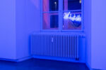 a picture of the gallery window that mirrors the neon sign with arabic letters in blue