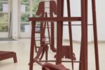 Exhibition view Art pavilion with red-painted wooden sculptures in various sizes and heights
