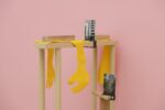 Exhibition view Kunstpavillon with wooden objects, photographs and yellow fabrics reminiscent of hands