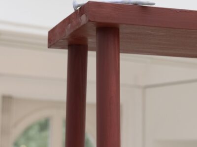 Ausstellungsansicht Kunstpavillon mit Nagel aus Gips auf roter Holzskulptur