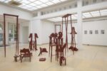 Exhibition view Kunstpavillon with red-painted wooden sculptures in various sizes and heights