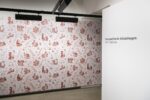 Ausstellungsansicht mit einer rötlichen Taptete mit floralem Muster, zeigt die Arbeit Balkangreuel