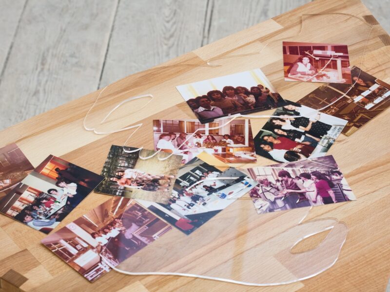 photographs on top of a wooden table with a transparent curvy object on top of it
