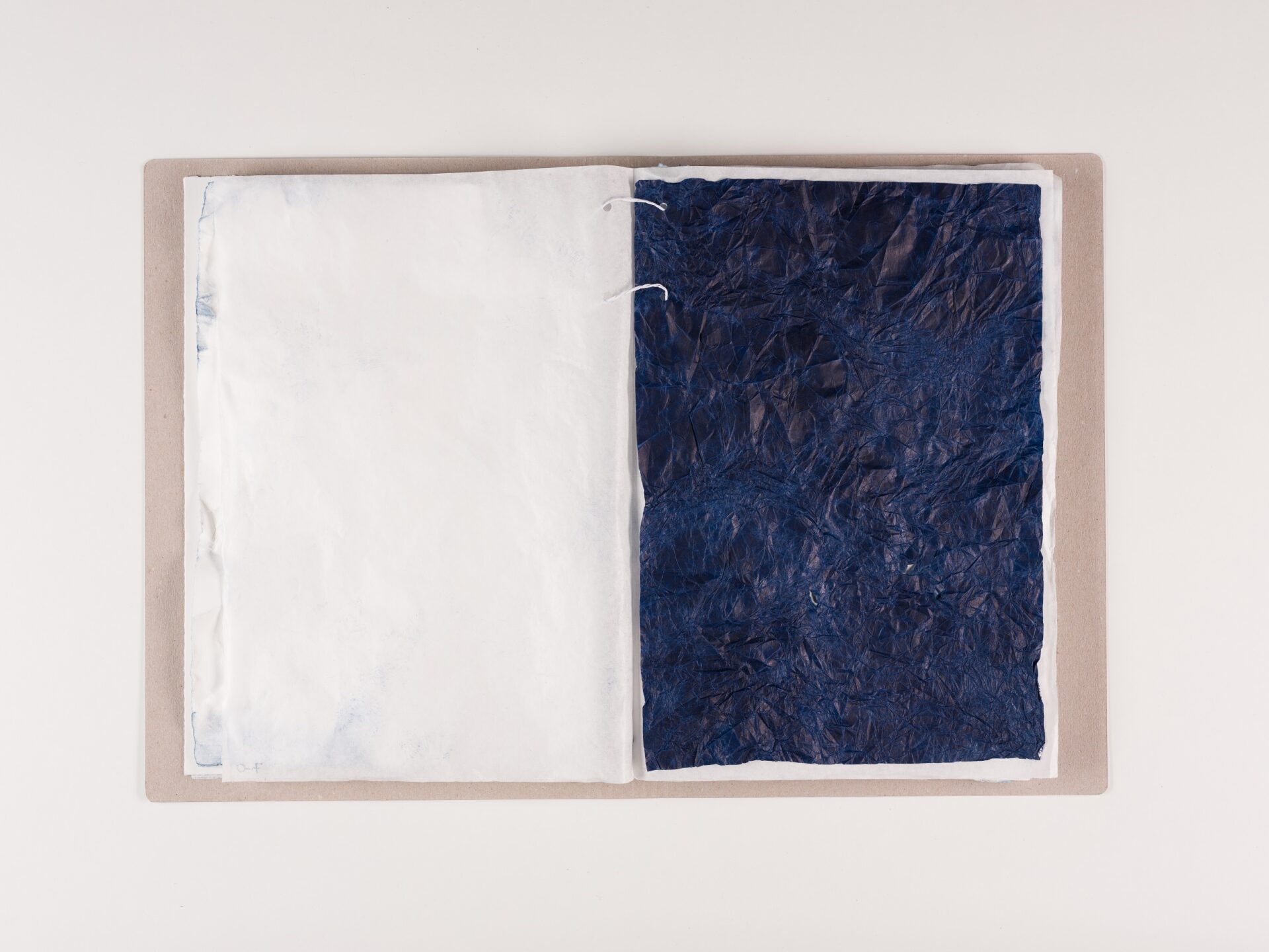 Foto von aufgeschlagener Akte, linke Seite weiß, rechte Seite dunkelblau