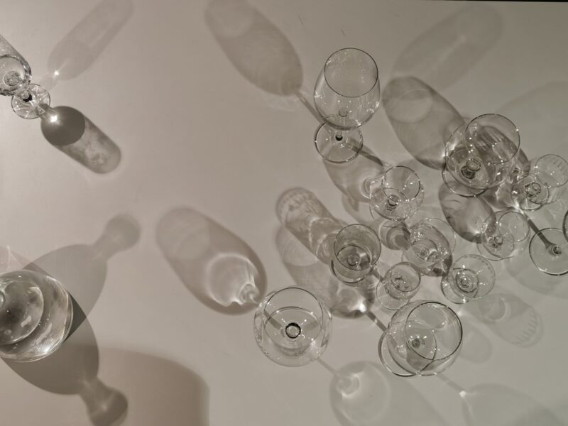 Photo of empty wine glasses on a white cloth and a glass carafe half-filled with water on the left