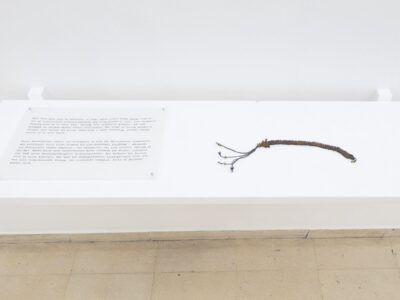 Foto Ausstellung mit Text auf der linken Seite und Gebetsband auf der rechten auf einer Ablage