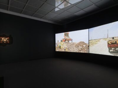 Foto aus Ausstellung zwei große projizierte Bilder in einem schwarzen Raum