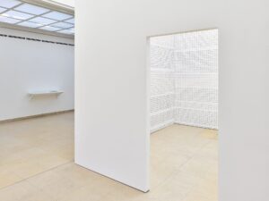 Photo exhibiton with a white cube and an entrance door
