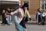 Documentation photo of the performance with a women dancing in a public square by people surrounded