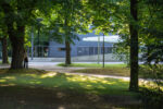 Documentation photo of the performance with a women leaning towards a tree in a garden