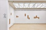 Photo of the exhibition at Kunstpavillon with text and wooden panels