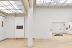 Photo of the exhibition at Kunstpavillon with text and wooden panels