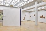 Photo of the exhibition at Kunstpavillon with text and wooden panels