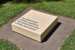 Photo of the exhibition at Kunstpavillon in the garden with a text on a low stand
