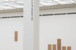 Photo of the exhibition at Kunstpavillon with text and wooden panels