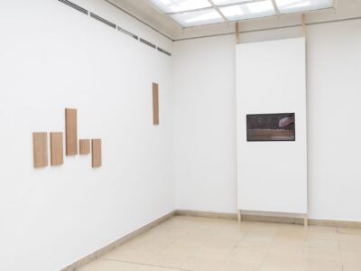 Ausstellungsansicht Kunstpavillon mit Holzpanelen an der Wand und Video mit einer Hand