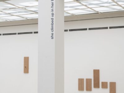 Ausstellungsansicht Kunstpavillon mit Holzpanelen an der Wand und Schrift
